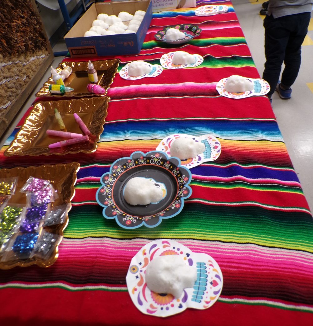 Photos of students and parents from Dia de los Muertos event - altar, artwork, decorating sugar skulls