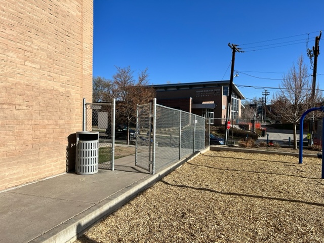 Photo of a chain-link fence outside of a school building.