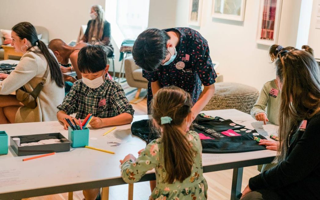 Photo of kids making art - sitting and standing at a table