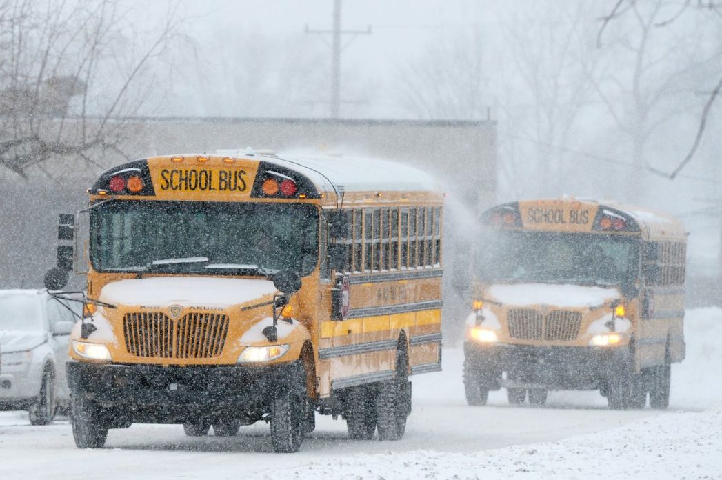 Photo of two yellow school buses in snowy weather