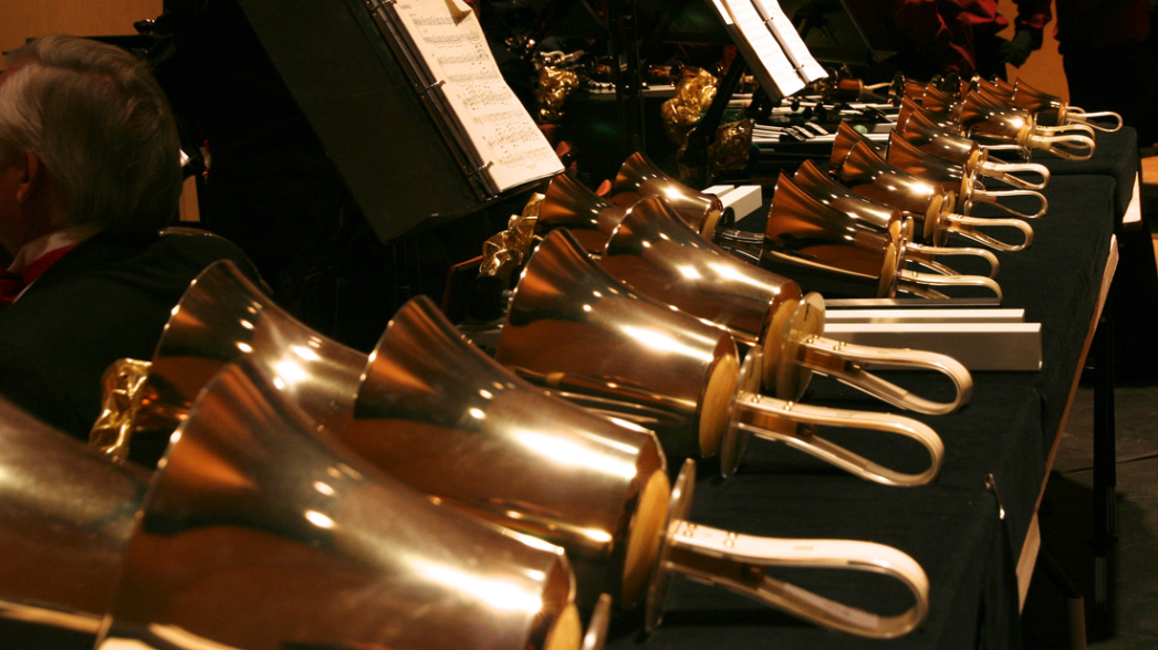 Photo of gold colored hand bells in a row