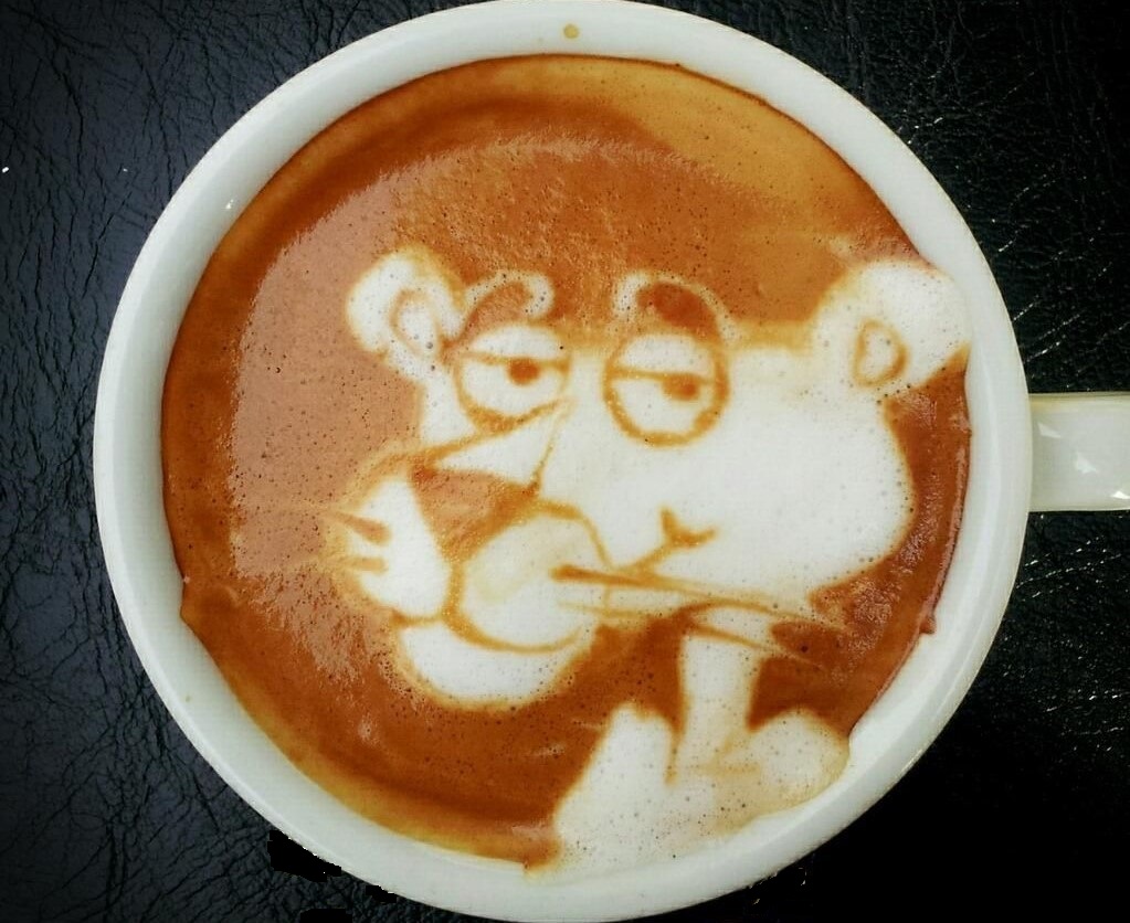 White coffee cup on black background; coffee has coffee foam in the shape of a panther