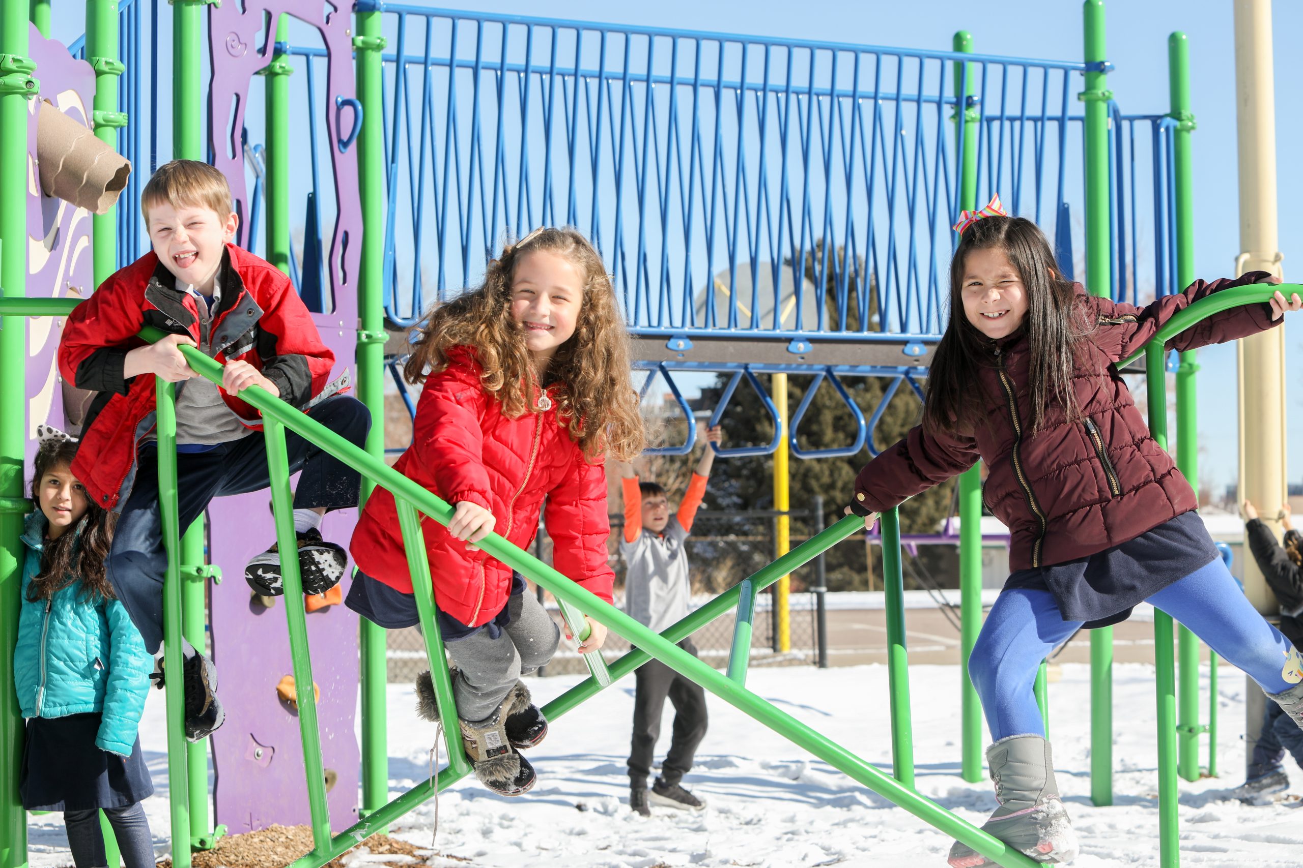 Image of students on playground equipment in the snow